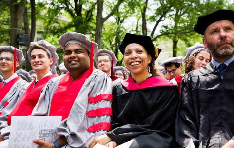 Doctoral candidates smile as Chancellor Barnhart addresses them from the stage; photo: Jake Belcher