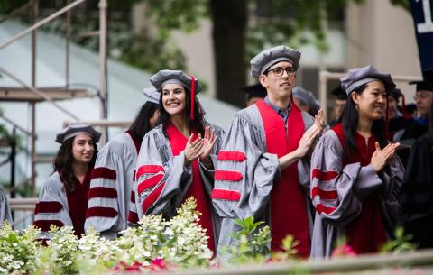 Doctoral candidates line up by the stage to receive their hoods and diplomas; photo: Jake Belcher