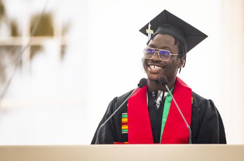 Photo of Temiloluwa O. Omitoogun at the podium delivering the salute from the undergraduate students