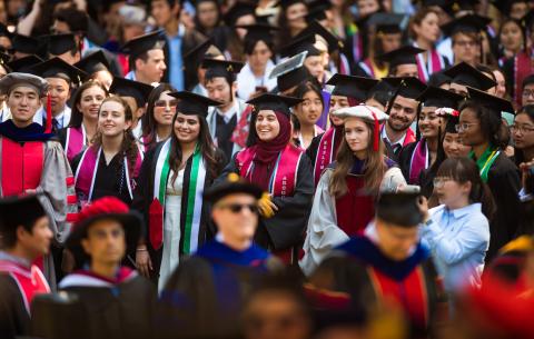 Image of 2023 graduates smiling as they watch the Academic Procession